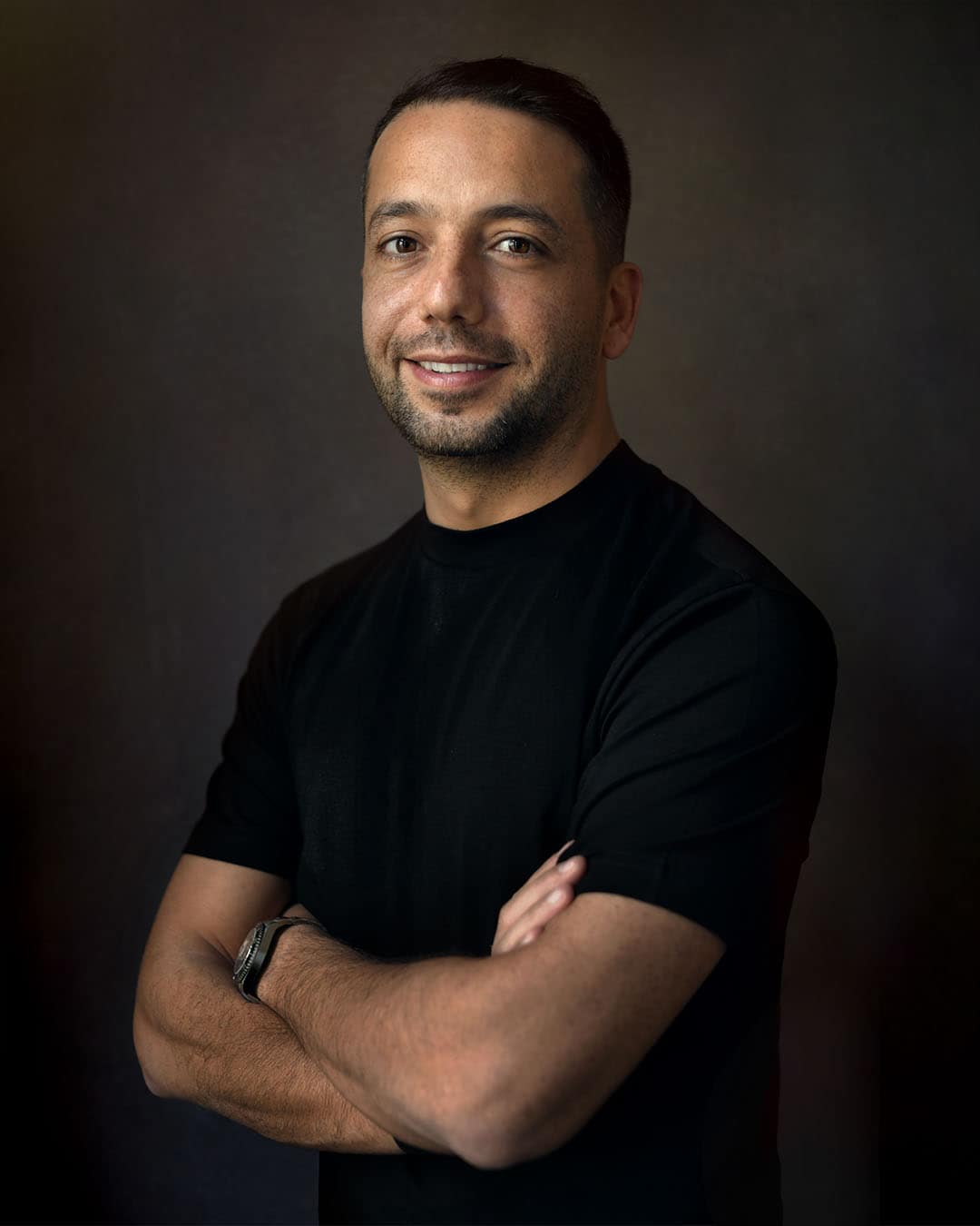 Modern business headshot of a man in black t-shirt, fine art backdrop, captured in Dubai