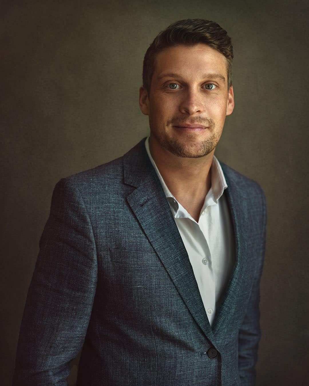 Professional LinkedIn headshot photographed in Dubai using natural window light and a fine art portrait style.
