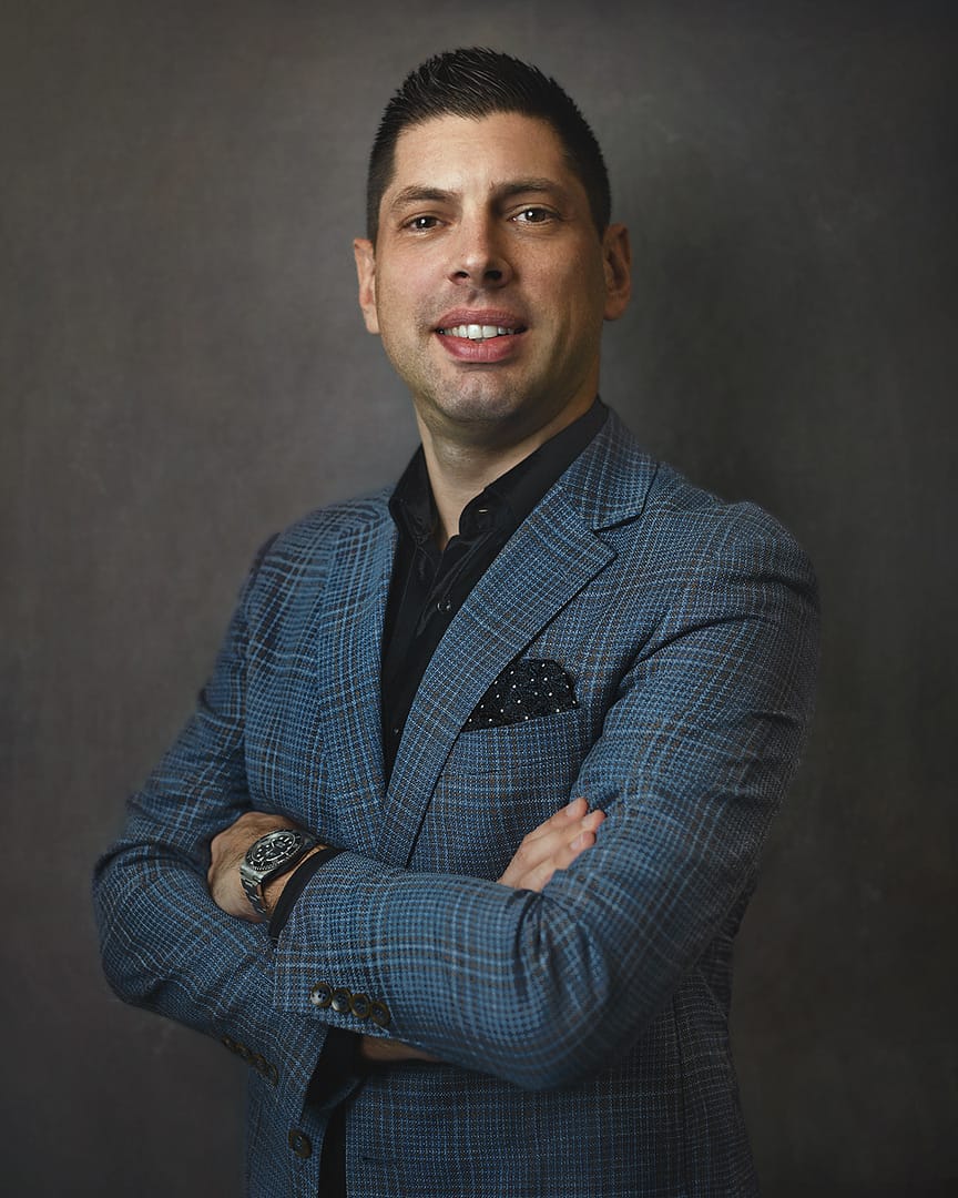 Professional headshot of a man in a checked blazer, demonstrating ideal LinkedIn profile photo attributes.